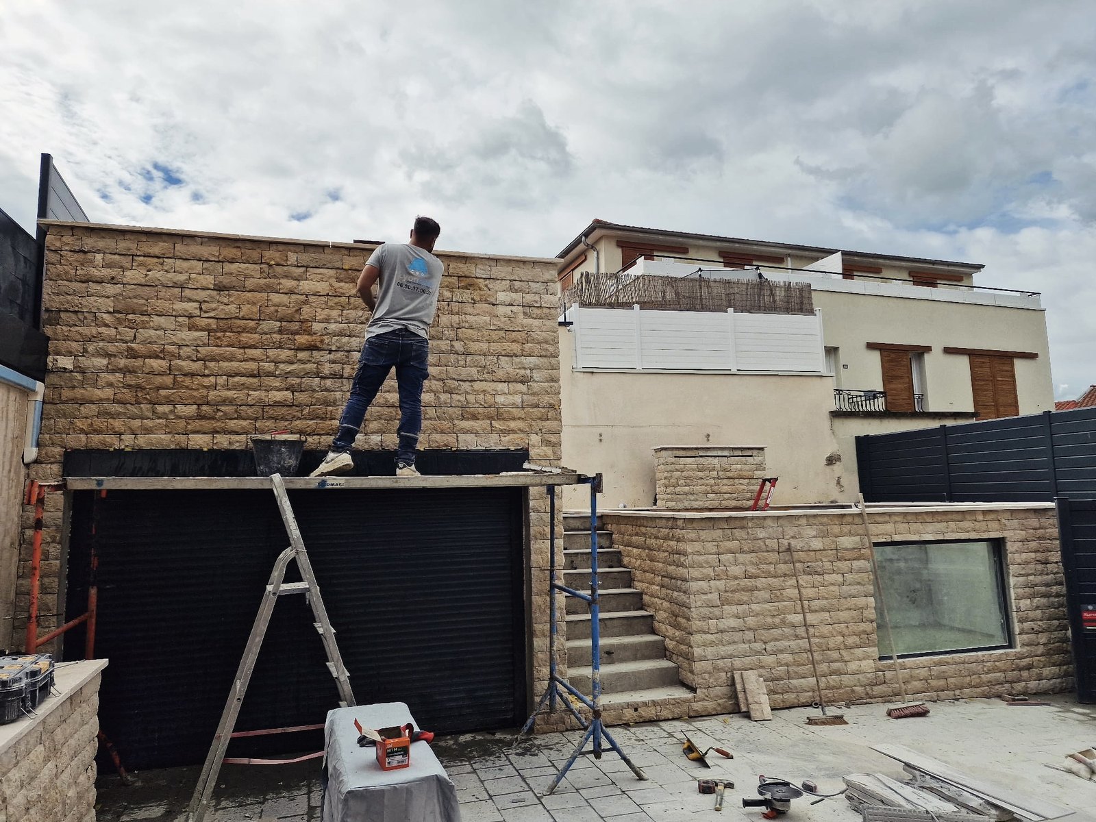 Agrandissement en cours : maçon Lyonblue sur l'échafaudage d'une construction en pierre