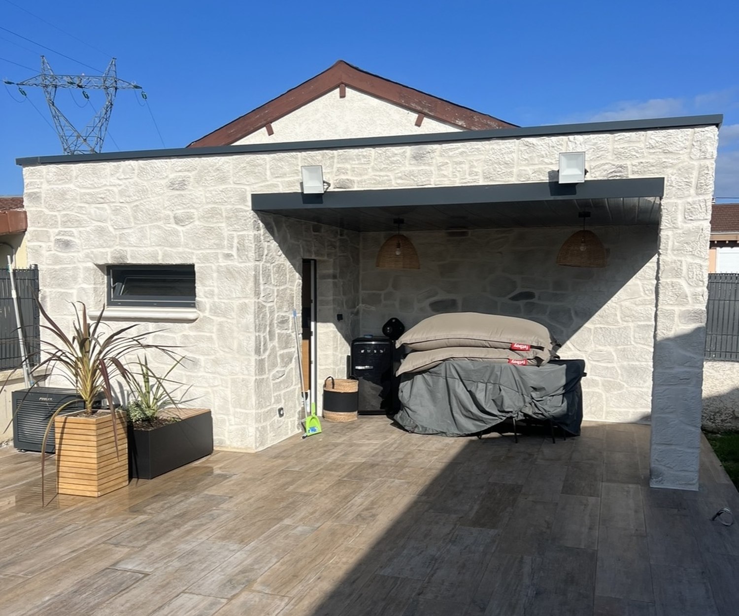 Agrandissement en pierre avec préau et terrasse carrelée réalisé par Lyonblue