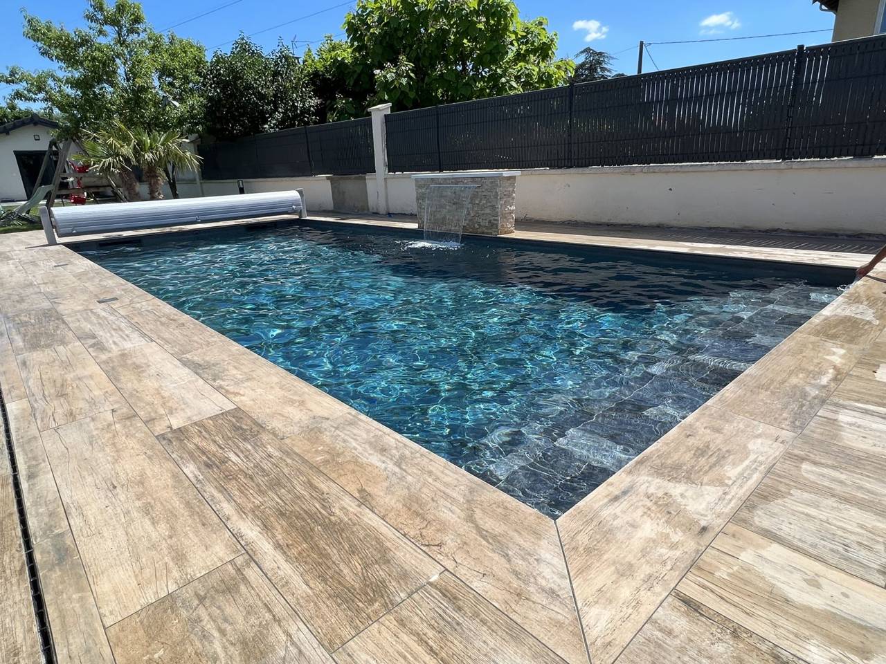 Terrasse en carrelage effet bois autour d’une piscine à Villeurbanne